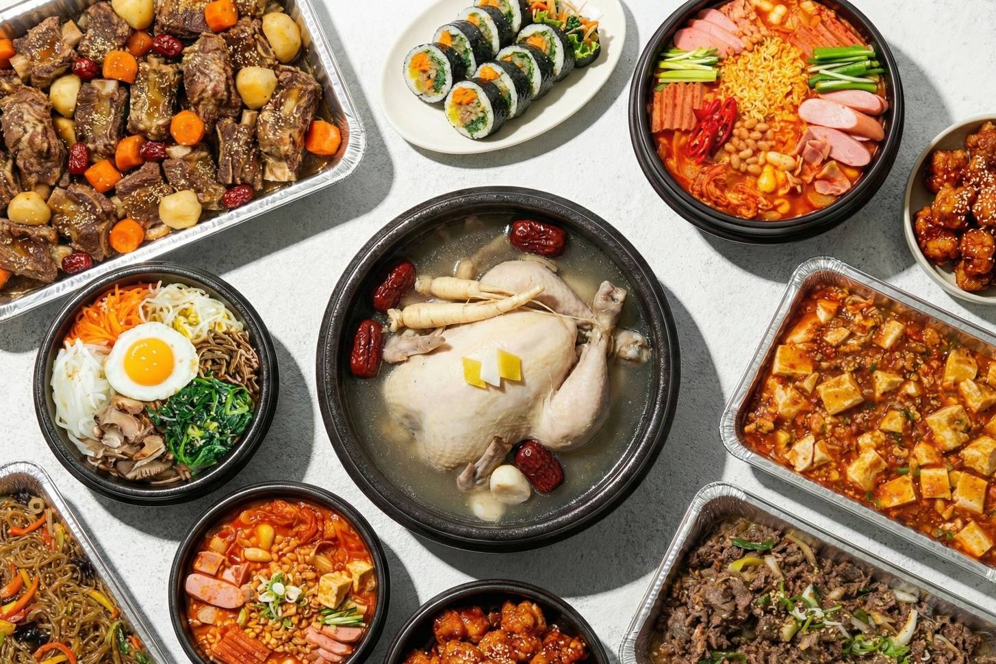 Korean catering spread: galbi-jjim, kimbap, budae jjigae, samgyetang, bibimbap, mapo tofu, japchae, bulgogi, wings